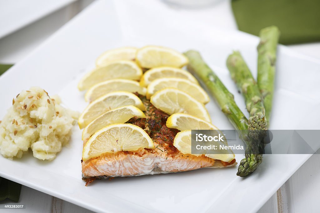 Healthy Food Consisted of Salmon and Vegetables Detail of grilled salmon with slices of lemon on it with mashed cauliflower and green asparagus. Proteins, green vegetables, oil and carbs, the perfect match for a balanced healthy lifestyle. The point of view is from top, ready to eat. Asparagus Stock Photo