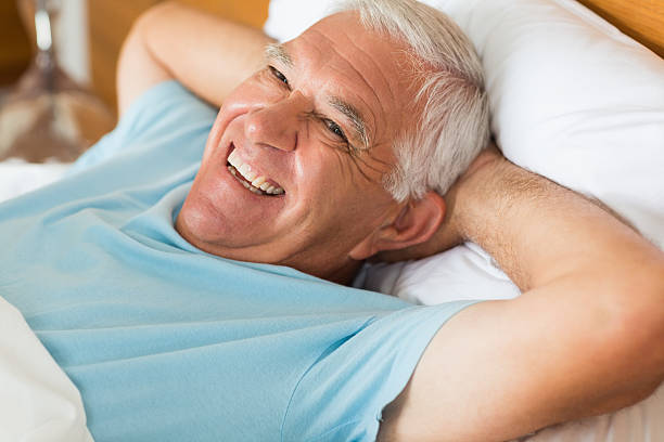 istock Cheerful senior man lying in bed 493283121