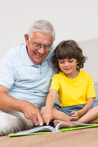 istock Senior man with grandson reading book 493283161