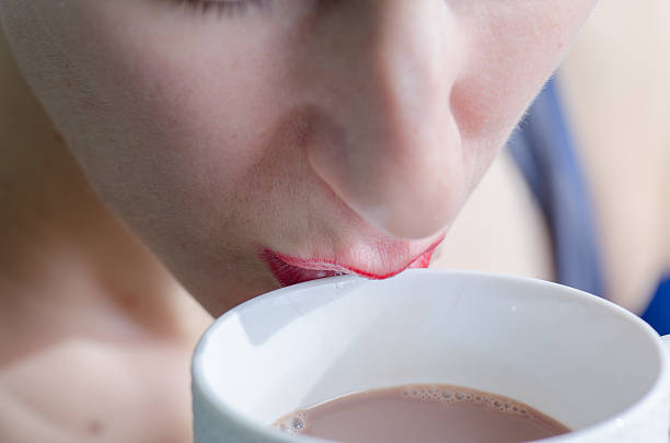 istock Close up on woman drinking in white cup 493284010