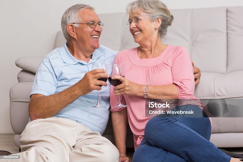 Romantic senior couple toasting wineglasses Romantic senior couple toasting wineglasses in living room at home 60-64 Years Stock Photo