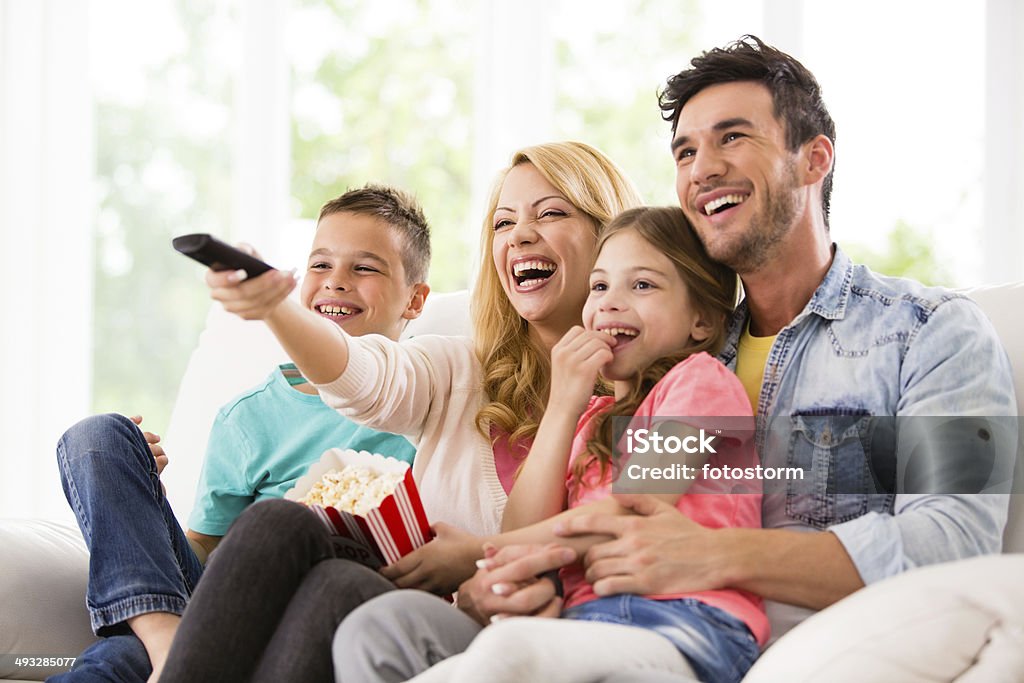 Glückliche Familie vor dem Fernseher und Essen popcorn - Lizenzfrei Familie Stock-Foto