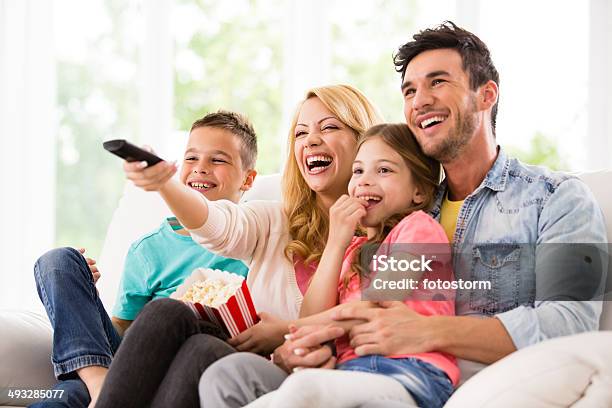 Happy Family Watching Tv And Eating Popcorn Stock Photo - Download Image Now - Family, Watching TV, Television Set