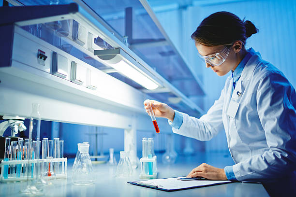Testing substances Young woman working with liquids in glassware biochemistry stock pictures, royalty-free photos & images