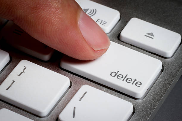 のクローズアップの指には、キーボードの delete キーを。 - deleting ストックフォトと画像