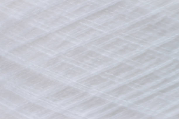 istock blur of texture of white thread in spool 493303966