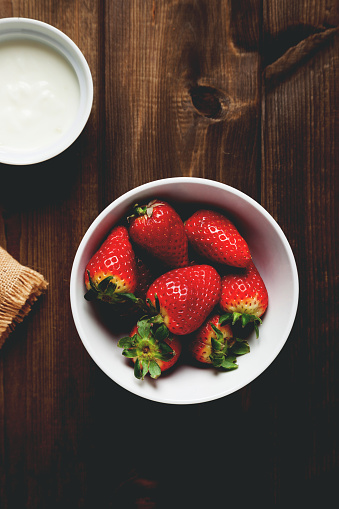 strawberries with yogurt on background prepared on wooden table