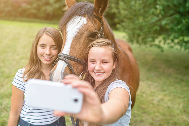selfies filles avec un téléphone mobile de la frappe les autoportraits avec cheval - horse animal head laughing animal photos et images de collection