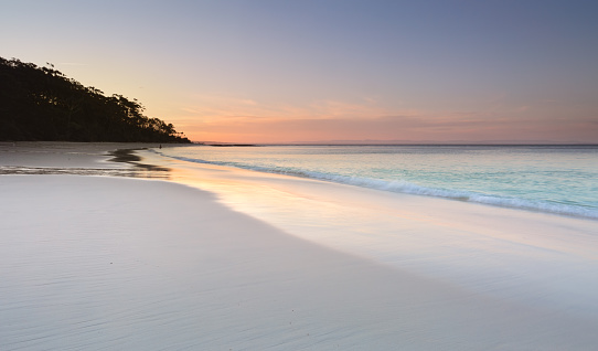 Serenity and peace at sundown on Murrays Beach in Booderee National Park, Jervis Bay Australia.  Pretty soft colours in the sky and reflecting in the wet sand.  A tranquil place to unwind from life's busyness or troubles
