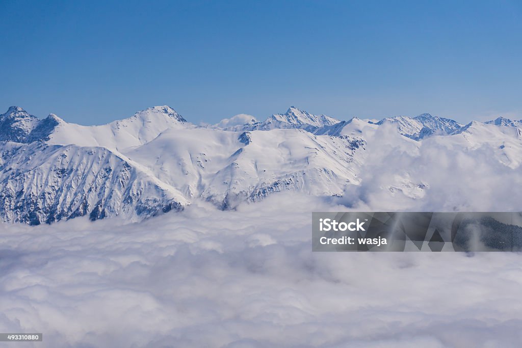 View on mountains and blue sky above clouds, Krasnaya Polyana View on winter snowy mountains and blue sky above clouds, Krasnaya Polyana, Sochi, Russia 2015 Stock Photo
