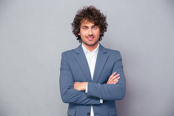 istock Cheerful businessman standing with arms folded 493311138
