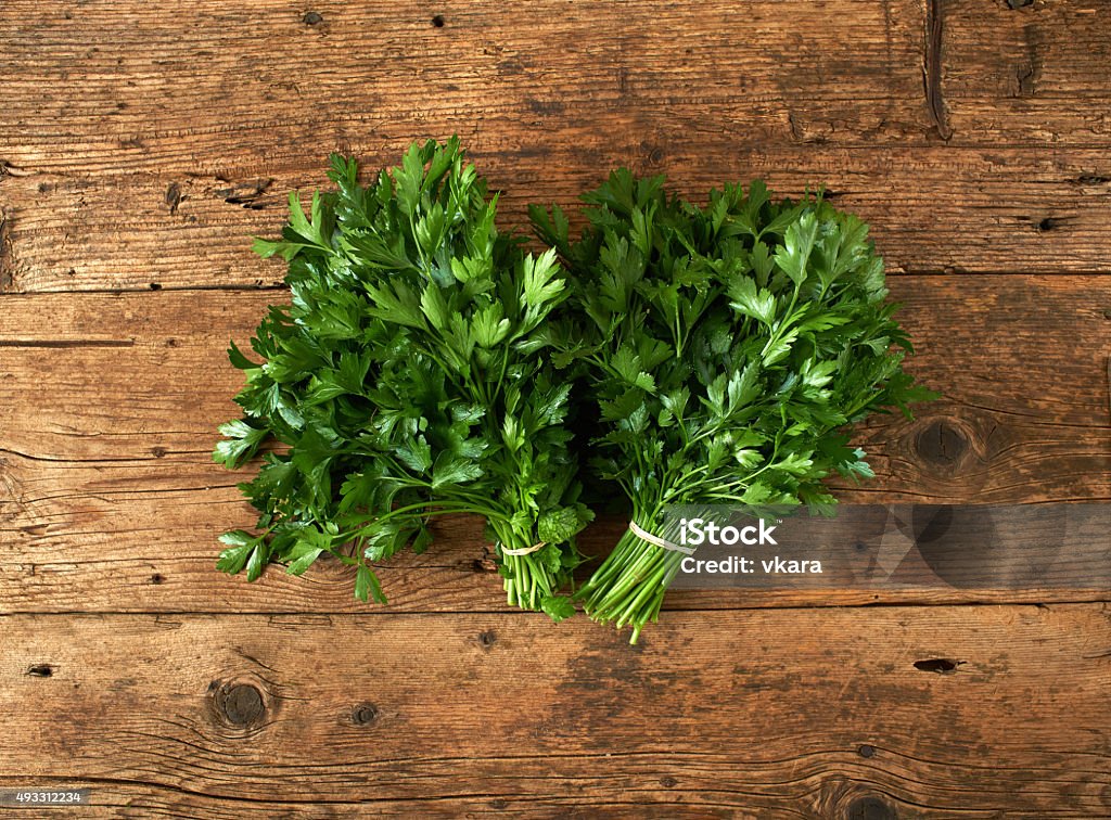 bunches of fresh parsley on wooden bench bunches of fresh parsley on a wooden bench Parsley Stock Photo