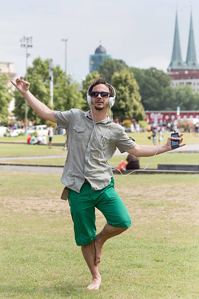 istock Young man enjoying music on smartphone in yoga pose 493319737