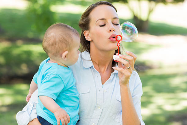 istock Mother blowing bubble while carrying baby 493323001