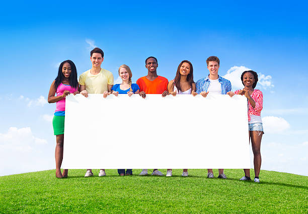 istock Multiethnic Teenagers Outdoors Holding Empty Billboard for Copy 493323367