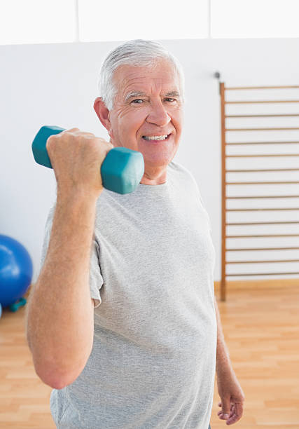 istock Fit senior man lifting hands weight 493325337