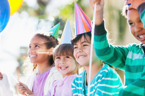 Multi-ethnic children at birthday party.  Focus on two little girls in middle (3 and 5 years, mixed race, Hispanic / Caucasian).