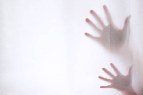 Hand silhouettes behind curtain foreground