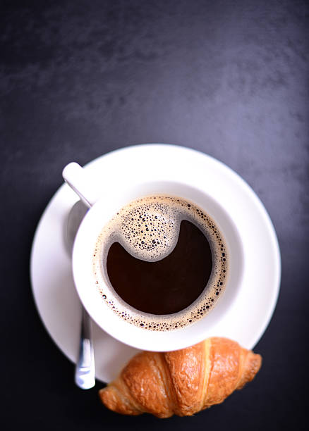 istock Croissant and cup of coffee on black background 493329040