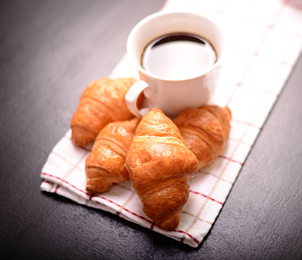 istock Croissant and cup of coffee on black background 493329126