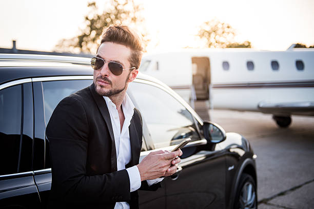 istock Man with phone next to SUV on airport track 493330696