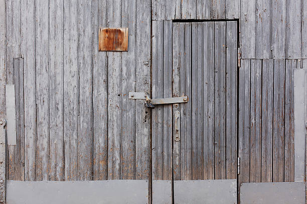 istock Old grey wood locked door on grunge grey wall 493330852