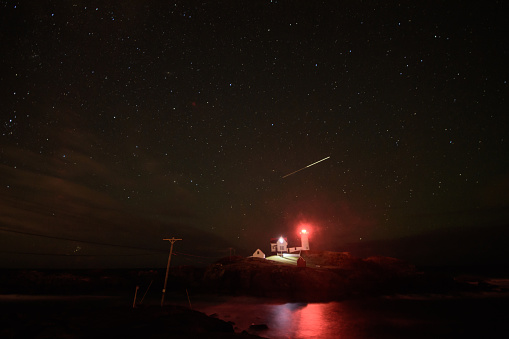 This historic lighthouse in Cape Neddick Maine sits guarding the ships off the coast of maine should GPS navigation fail a weary captain. A shooting star painted it's path across the sky like a bright game of connect the dots.