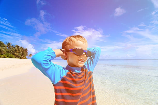 istock happy boy in swimming goggles on beach 493332390