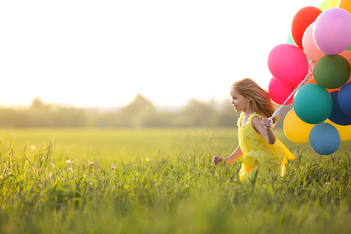 Little girl with balloons outdoors