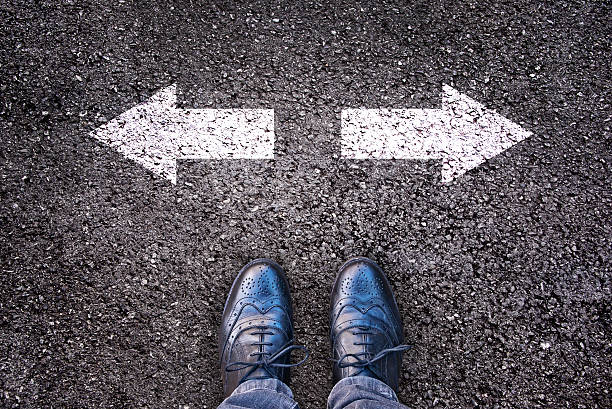 istock Feet and two arrows painted on an alphalt road 493337900