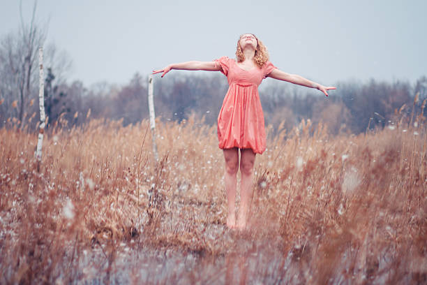 Young woman in wheat field at sunset