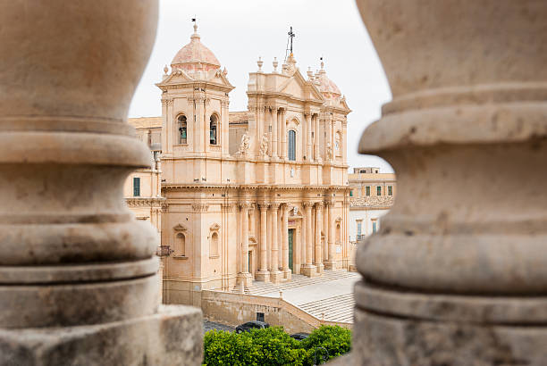 The baroque cathedral of Noto, seen through two columns stock photo