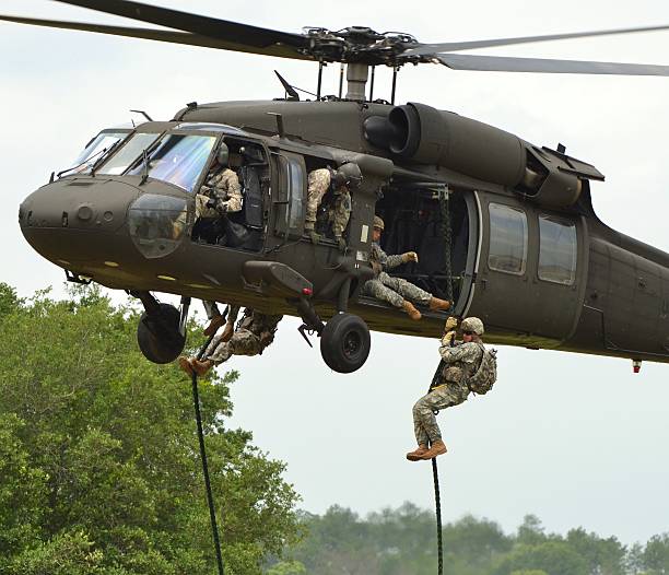 UH-60 Black Hawk Florida, USA - May 12, 2012: A Sikorsky UH-60 Blackhawk operated by the Army Rangers. Troops are fast-roping to the ground. blackhawk stock pictures, royalty-free photos & images