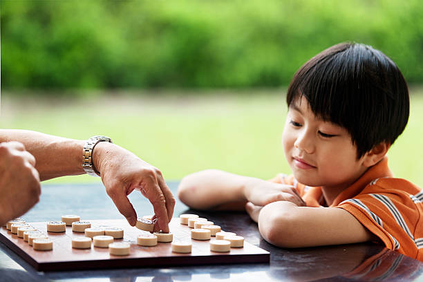 istock Grandfather and grandson playing Xiangqi (chinese chess) 493374725