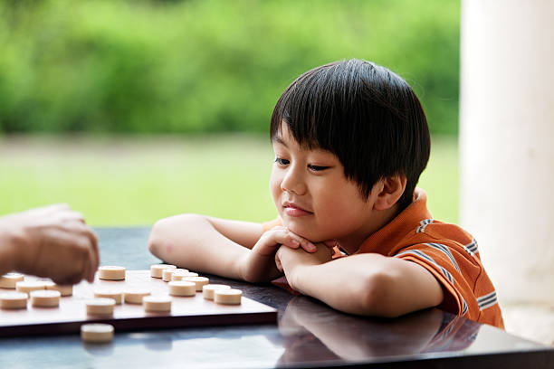 istock Grandfather and grandson playing Xiangqi (chinese chess) 493374729