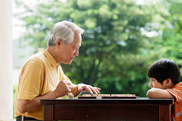 istock Grandfather and grandson playing Xiangqi (chinese chess) 493374739