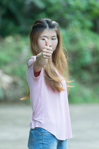 istock asia young women showing thumbs up 493374854