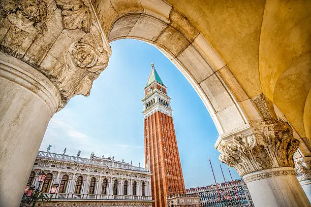Famous Venetian Palazzo Ducale with view of Piazza San Marco, Venice, Italy. Beautiful abstract view of Venetian tower with column like a frame of the photo.