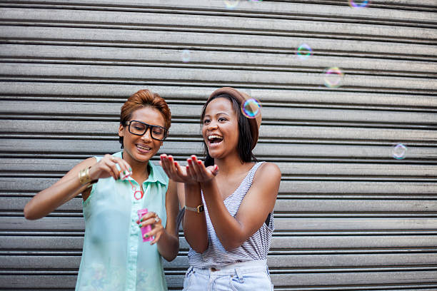 istock Two African girls blowing bubbles 493378437