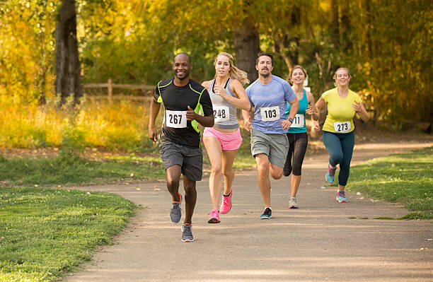 istock Group of young adults running in a race 493378878