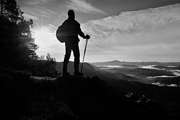 istock Tourist guide watching into deep misty valley bellow. 493380234