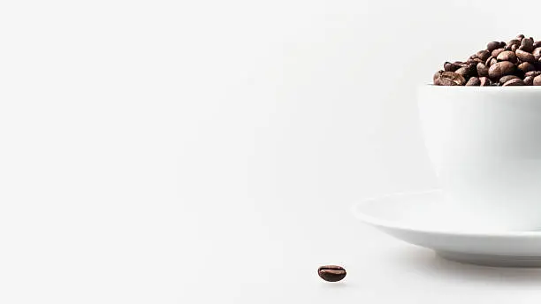 Coffee background. Cup of coffee and coffee beans on the white 