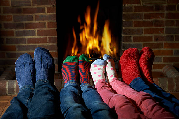 istock Family Wearing Socks Warming Feet By Fire 493387256