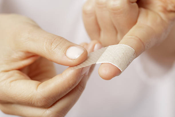 Band aid Forefinger of a woman hand with a band aid wounded stock pictures, royalty-free photos & images