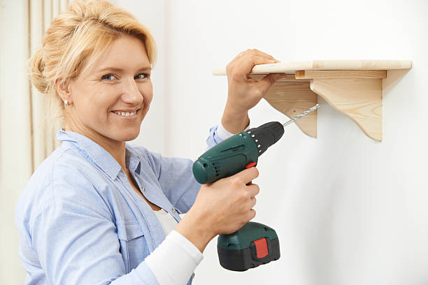 mulher colocando up de prateleira de madeira em casa com a furadeira sem fio - shelf drill drilling installing - fotografias e filmes do acervo