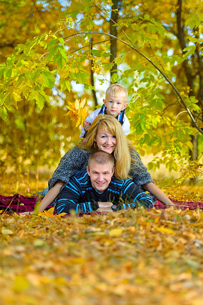 familia feliz otoño caminando en la naturaleza - middle human age leaf tree fotografías e imágenes de stock