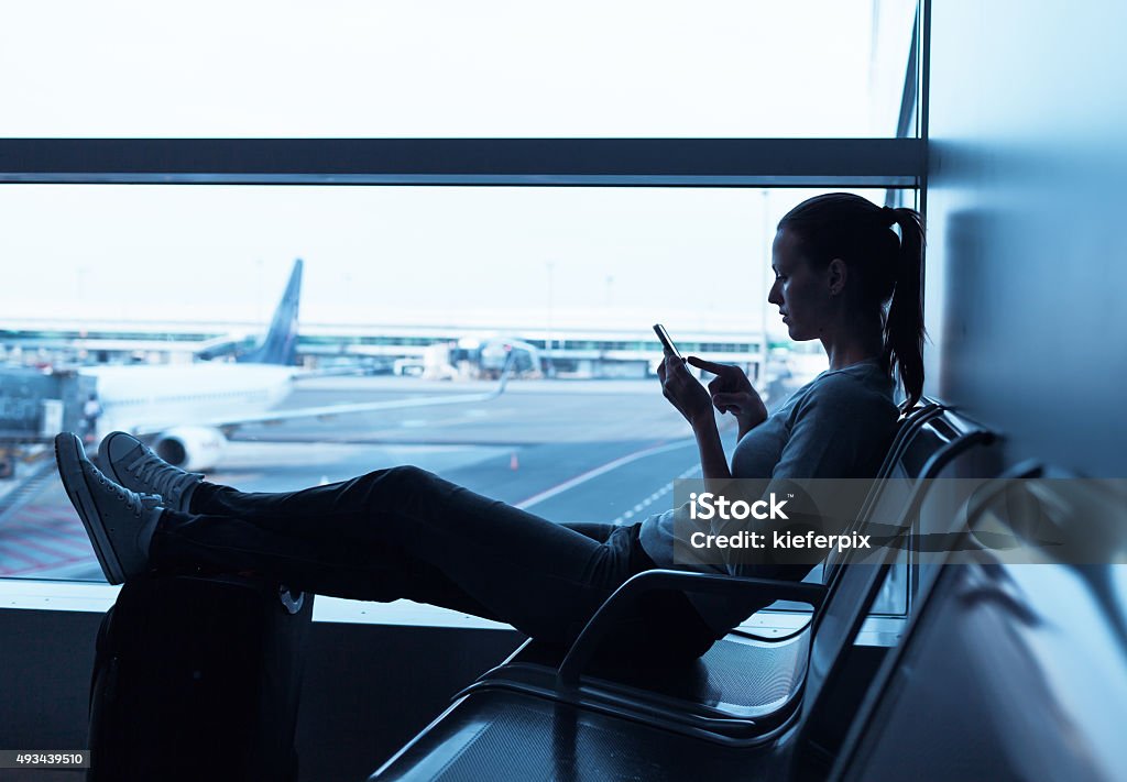 Woman waiting at the airport Woman using internet in the airport terminal Banking Stock Photo