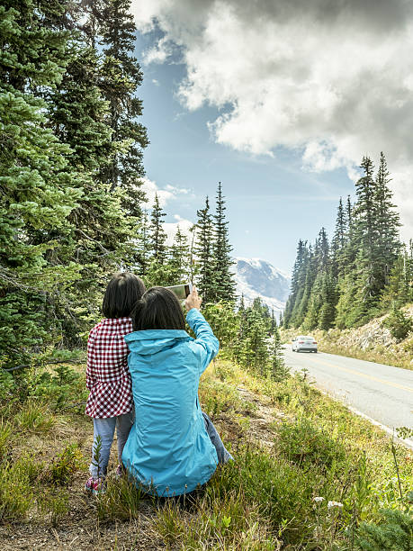 istock mother taking picture with daguhter  at MT.Rainier 493440106