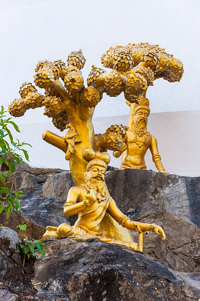 Murudeshwar, Karnataka, India - January 6, 2015:  Golden sculptures of Vyasa the sage sitting and meditating on the rocks in different poses in Murudeshwar Temple complex.