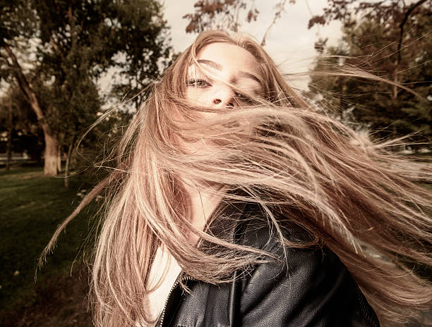 istock Young woman with hair swept by wind 493442350